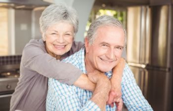 Smiling elderly couple after dental implant restoration in Topsfield MA.